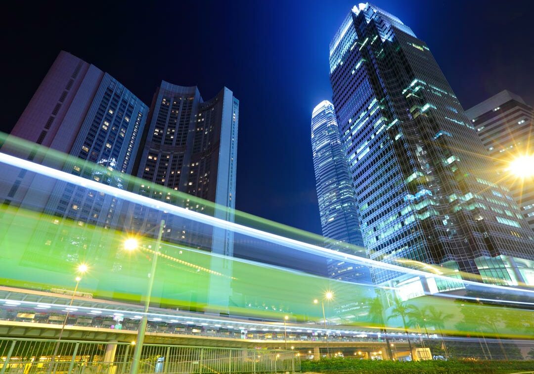 city skyline at night with blurred car lights passing by